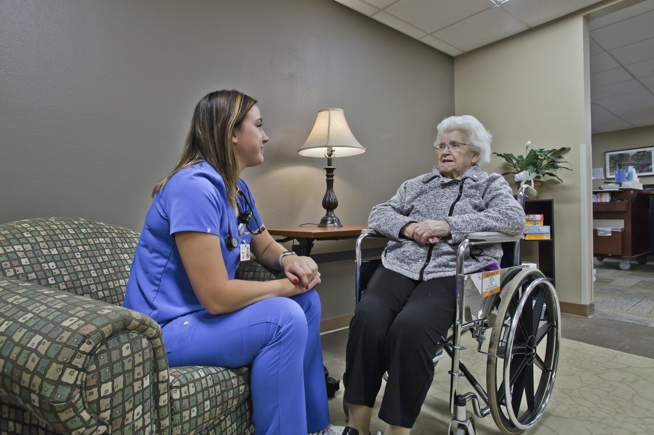 nurse talking with woman in wheelchair