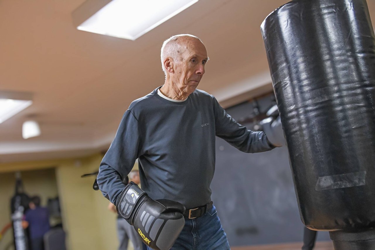 Image of an older man in gray shirt boxing in senior fitness center