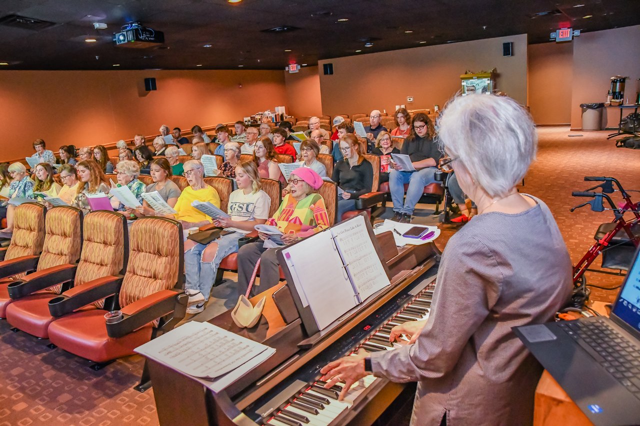 woman playing piano for crowd