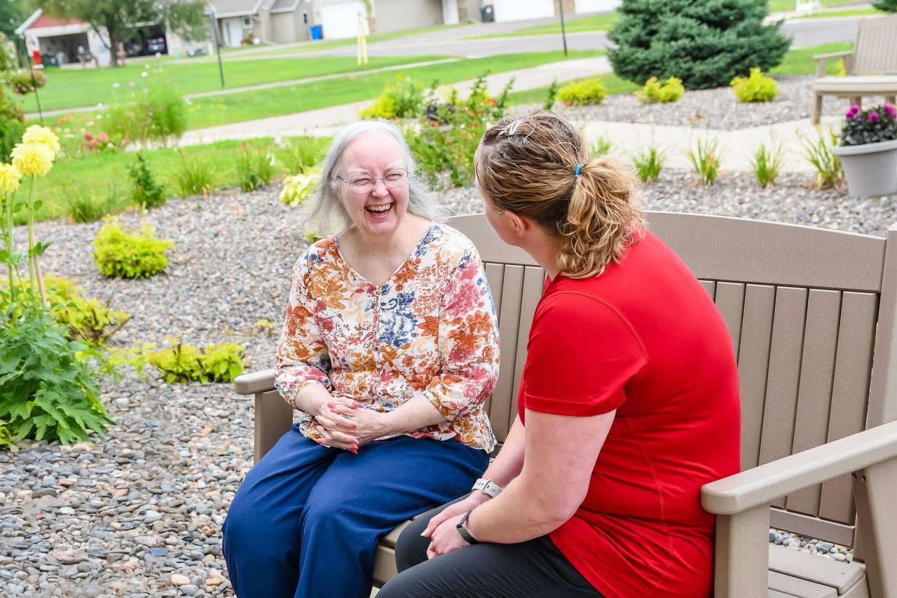 women laughing on bench