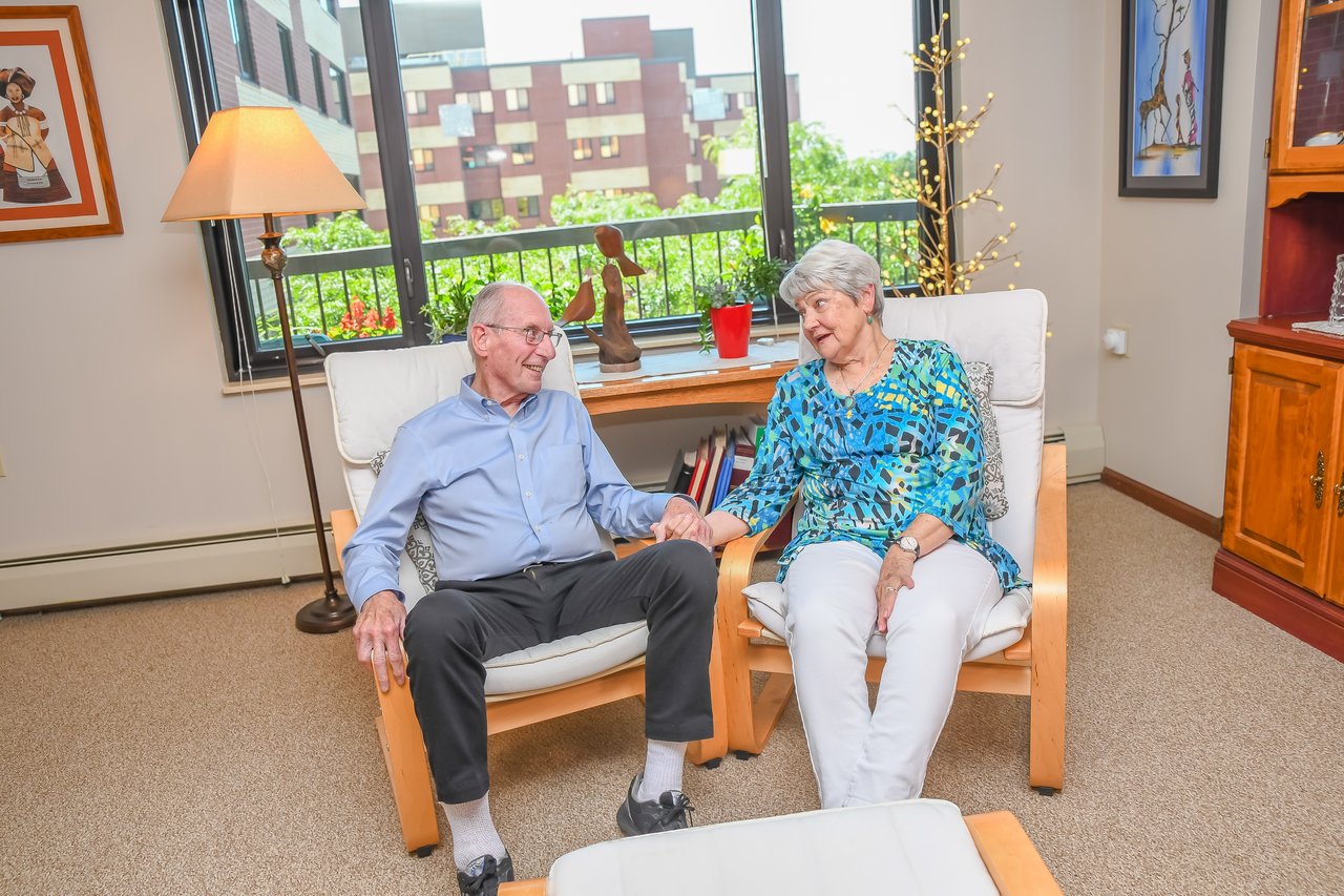 happy couple holding hands in front of large window