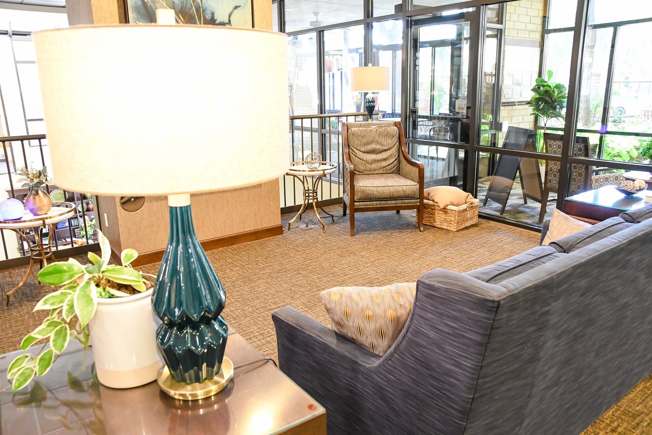 bright lobby with lamp, sofa, and chairs