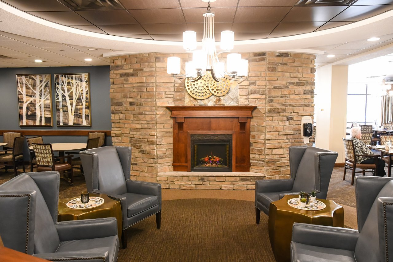 bright lobby with chandelier, fireplace, and chairs