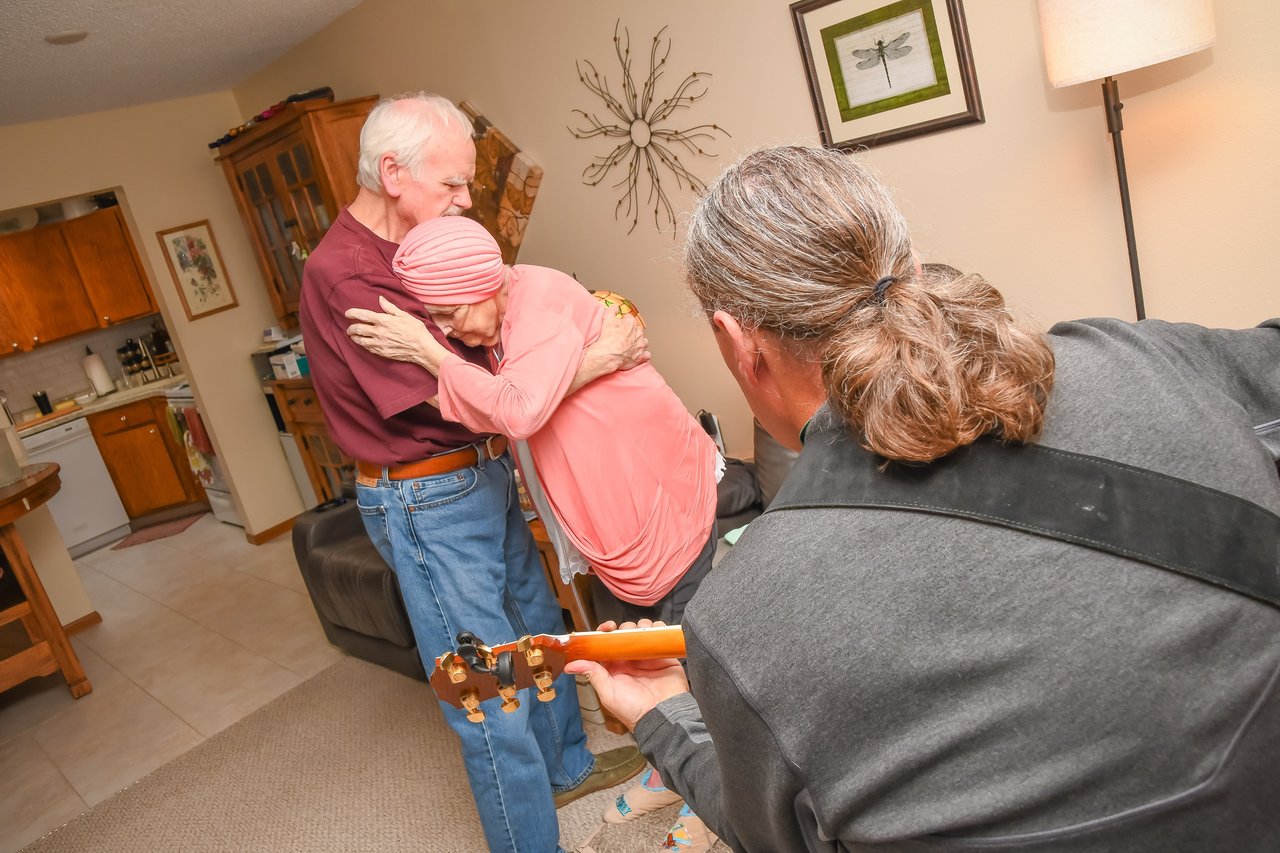 man playing music for dancing older couple